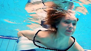 Redhead babe swimming naked in the pool